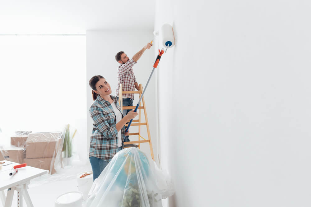 young couple is painting the house before they sell